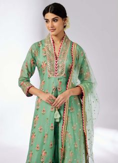 Elevate your style with this delicately embroidered ensemble that adds shimmer and richness. The long-sleeved, front-open kurta in luxurious cotton silk pairs beautifully with linen satin palazzo pants and a sheer net dupatta. Easy to carry and perfect for any occasion, this set effortlessly blends elegance with versatility. Festive Pant Set With Sheer Dupatta, Festive Green Pant Set With Traditional Drape, Festive Green Traditional Drape Pant Set, Bollywood Style Pant Set With Sheer Dupatta For Festivals, Eid Slub Silk Palazzo Set With Sheer Dupatta, Festive Pant Set With Sheer Dupatta For Navratri, Floor-length Pista Green Chanderi Kurta, Pista Green Chanderi Floor-length Kurta, Pista Green Floor-length Chanderi Kurta