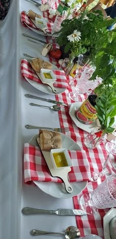 a long table is set with plates and utensils for an outdoor dinner party