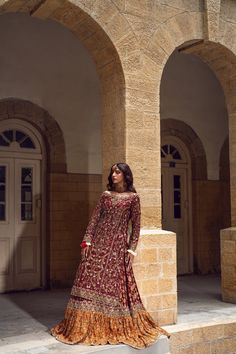 Pakistani Bridal Dress in Farshi Lehenga Kameez Style is a heavily embellished attire adorned with Goldwork and Floral designs. Dabka, Threads, Tilla, and embroidery make this stunning Lehenga Dress an epitome of beauty and your foremost priority for the wedding. Lehenga Kameez: The stunning kameez in an alluring red color is beautifully embellished with the intricate zardosi and shimmering silver gold work. Dabka, embroidery, threads, sequins, and motifs make this red kameez a perfect choice to wear on the big day. Intricate design on the kameez give it a flawless finishing look. Bridal Lehenga: The embellished kameez is paired with Bridal Lehenga, creating a lavish Pakistani Bridal Outfit. The Farshi Lehenga has an alluring contrast of red and orange shade and is gracefully emblazoned wi Designer Dabka Choli With Long Sleeves, Designer Long Sleeve Choli With Dabka Details, Designer Long Sleeve Dabka Choli, Anarkali Traditional Wear For Eid Reception, Traditional Floor-length Dupatta For Reception, Eid Reception Anarkali Traditional Wear, Embroidered Kundan Floor-length Gown, Kundan Anarkali Dress For Wedding, Eid Reception Dress With Dabka Detailing