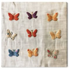 six different colored butterflies on a white cloth