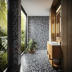 the bathroom is decorated in black and white floral wallpaper, along with potted plants