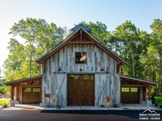 a large barn with two garages and an american flag on the top of it