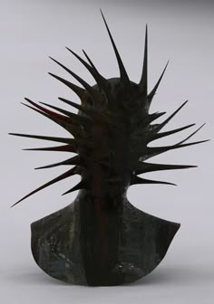 a black sculpture with spikes on it's head