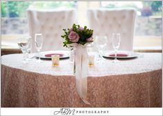 the table is set with white and pink flowers