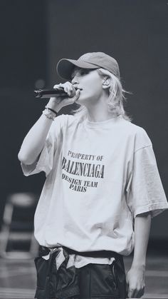 a woman standing on top of a stage with a microphone in her hand and wearing a t - shirt that says property of balcanna