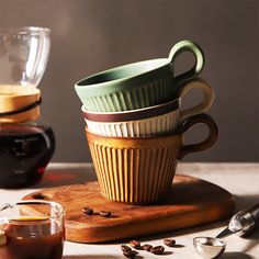 there are many cups and spoons on the table next to each other with coffee in them