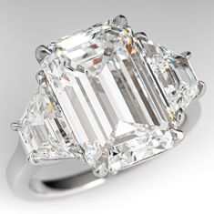 an emerald - cut diamond ring with three baguets on the shoulders and sides