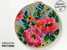 a cross stitch pattern with flowers and leaves on the hoop, in front of a white background