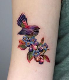 a small bird with flowers on the arm