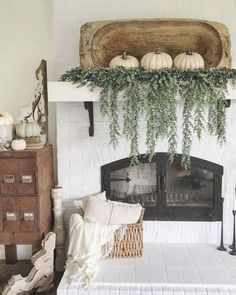 a living room filled with furniture and a fire place covered in greenery on top of a mantle