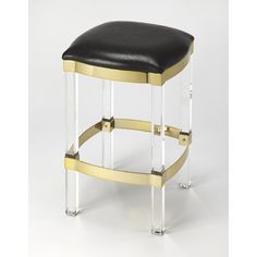 a black and white stool with gold trimmings on the bottom, sitting in front of a white background