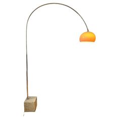 a floor lamp with an orange shade on the top and bottom, in front of a white background