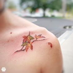 a man with a tattoo on his shoulder has leaves painted on it's chest