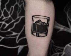 a black and white photo of a glass with ice cubes in it on the arm