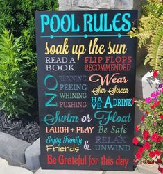 a pool rules sign in front of some flowers and plants with the words pool rules written on it