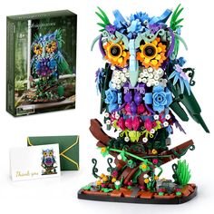 an owl made out of legos sitting on top of a table next to a box