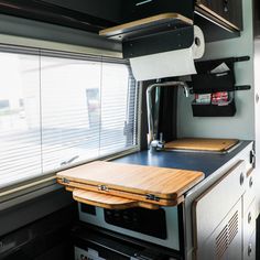 a kitchen area with a cutting board on the stove top and window in the background