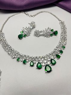 Gorgeous fine quality imitation jewellery faux Emerald green with CZ  diamonds studded necklace with white gold rhodium plating and matching Earrings Item contains: Necklace and earrings AAA quality cubic zirconia used. Highest quality and craftsmanship Necklace Fitting is adjustable Earrings Closure: Pushback Necklace Closure: chain with Hook Details-  -Handmade item -Delivery from a small business in India -Materials: white rhodium, stones, cz, zircon, American diamond -Jewellery type: Earrings, Necklace -Style: Art deco *CARE INSTRUCTION* You can use Jewelry for years together with the help of below jewelry care instructions. * Protect from sharp blows/scratches and extreme temperature. * Avoid contact with perfumes, sprays, chemicals and water. * Keep in a clean, dry and airtight Zip-p Gem Stone Necklace, Necklace Closure, American Diamond Jewellery, Tiffany Necklace, Green Gem, Emerald Green Color, Zirconia Necklace, Studded Necklace, Color Necklace