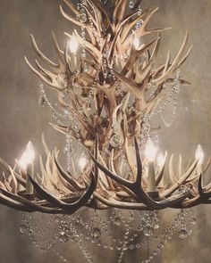 a chandelier with antlers hanging from it's sides and crystal beads