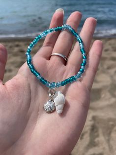 A very beach seashell bracelet set with turquoise colored beads. The set includes two turquoise beaded bracelets with seashell charms! Bracelet 1: Silver starfish charm and silver clam shell charm Bracelet 2: White seashell charm and silver seashell charm A perfect bracelet set for beach lovers! Cheap Beaded Bracelets With Heart Beads For Beach, Beach Beads Bracelets, Shell Charm Bracelet, Sea Shells Bracelet, Sea Shell Bracelet Diy, Turquoise Beaded Bracelets For Beach Season, Turquoise Beaded Bracelets With Starfish Charm, Ocean-inspired Turquoise Beaded Bracelets For Gift, Beachy Turquoise Round Bead Jewelry