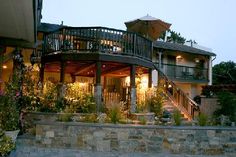 an outside view of a house with stairs and patio furniture at dusk, in the evening