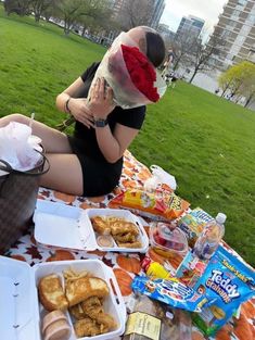 a woman sitting on the ground with food in front of her