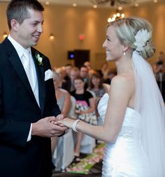 a bride and groom standing next to each other in front of an audience at a wedding