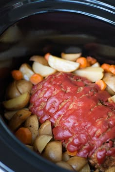 meat and vegetables are being cooked in the crock pot with sauce on top,