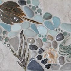 a mosaic with sea glass and shells on it