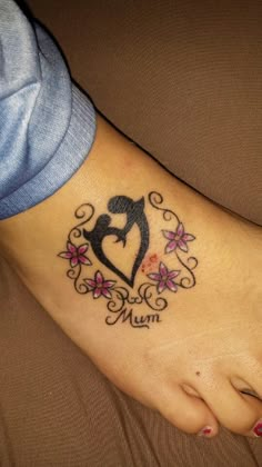 a woman's foot with a heart and flowers tattoo on the bottom of it