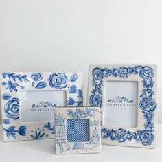 three blue and white frames sitting on top of a table