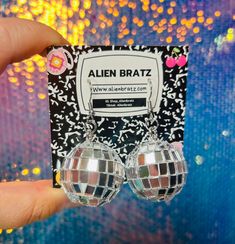 These extra cute statement earrings feature a dangle of a mirrored disco ball for a fun retro look! Made by Alien Bratz, a pop-culture and nostalgia inspired line based out of Philadelphia. Surgical Steel ear wires. 2" long. Disco Alien, Diy Disco Ball, Earrings Weird, Disco Ball Earrings, Weird Earrings, Hearts Playing Cards, 70's Disco, Pop Culture Gifts, Earrings Funky