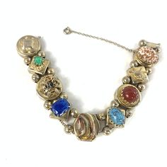 Victorian revival watch chain bracelet, made from reproduction watch and bracelet slides.  The bracelet is unmarked, but it is gold tone with high quality glass gems. It includes lapis style, Peking jade glass, Hubbell glass, and two gorgeous Italian Murano style and aventurine gems, plus a roaring lion and a bow. It's gorgeous and impressive, and this particular size and quality is VERY hard to find.  From the 1950's. I believe. Some wear, as expected, but in beautiful shape. Stones are not cho Vintage Jeweled Yellow Gold Jewelry, Vintage Yellow Gold Jeweled Jewelry, Collectible Vintage Jeweled Jewelry, Antique Jeweled Jewelry For Formal Occasions, Antique Formal Jewelry, Collectible Costume Jewelry With Jewels, Antique Jeweled Metal Bracelets, Antique Jeweled Jewelry, Collectible Metal Jewelry With Jewels