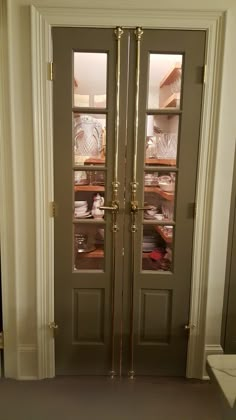 two glass doors with gold handles in a room