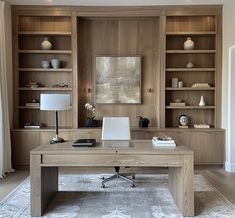 a home office with built - in bookcases and desk