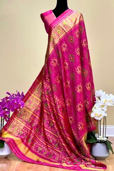 This beautiful single ikkat Patola saree in pink color is woven in narikunj design. The borders are woven in antique gold tissue with the ikkat design, and the pallu has a beautiful floral patterns. Approximate Length 6.5 mtrs (inclusive of blouse length)Height - 46 - 50" Saree comes with fall, picot and tassels done. Blouse piece is cut. Approximate weight - 1.2 lbs Kindly Note : The colors you see on your device may vary due to the color reproduction, brightness and resolution of individual devices. If you'd like more clarity before your purchase, please contact our support team. Pink Slub Silk Dupatta For Transitional Season, Navratri Ikat Print Pre-draped Saree, Pink Slub Silk Pre-draped Saree With Dupatta, Pink Paithani Silk Pre-draped Saree For Traditional Ceremonies, Multicolor Ikat Print Katan Silk Saree, Paithani Silk Ikat Print Traditional Wear, Banarasi Silk Ikat Print Saree For Wedding, Traditional Wear In Paithani Silk With Ikat Print, Traditional Ikat Print Paithani Silk Wear