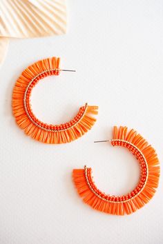 The Gracie Rattan Fan Hoops are the perfect accessory to elevate your tropical vacation style. These colorful rattan hoop earrings exude a playful and vibrant charm that complements any summertime outfit. Handcrafted with intricate attention to detail, each earring features a unique fan-shaped design, adding a touch of whimsy and exotic flair. Made from sustainable rattan material, these lightweight hoops provide a comfortable fit without compromising on style. Whether you're strolling along the Orange Summer Earrings For Vacation, Bohemian Orange Hoop Earrings For Summer, Orange Small Hoop Earrings For Summer, Trendy Orange Beaded Earrings For Summer, Summer Orange Small Hoop Earrings, Handmade Orange Hoop Earrings For Summer, Handmade Hoop Earrings For Summer Vacation, Trendy Small Hoop Earrings For The Beach, Orange Small Hoop Jewelry For Summer