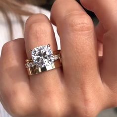 a close up of a person holding a ring with a diamond on the middle finger