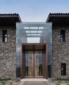 an entrance to a stone building with glass doors