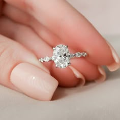 a woman's hand holding a diamond ring