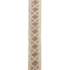 a white and brown ribbon with an intricate design on the end, in front of a white background