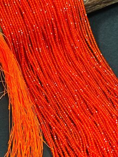 an orange beaded fabric with some beads on it