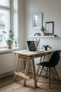 a laptop computer sitting on top of a wooden desk in front of a large window