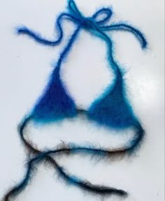 a piece of blue and white yarn on top of a white surface