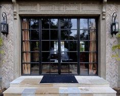 the entrance to a home with large windows