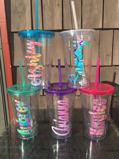 four different colored tumblers with the words happy birthday written on them and straws in each cup