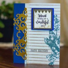 a close up of a card on a table with a potted plant in the background