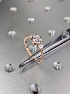 a diamond ring sitting on top of a piece of metal