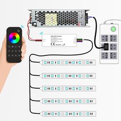 a hand holding a remote control next to multiple wires