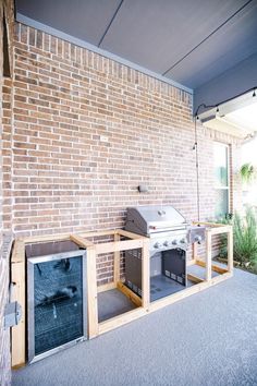 an outdoor bbq with two grills built into the side of it next to a brick wall